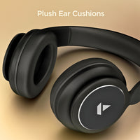 Black headphones with plush ear cushions on a beige background